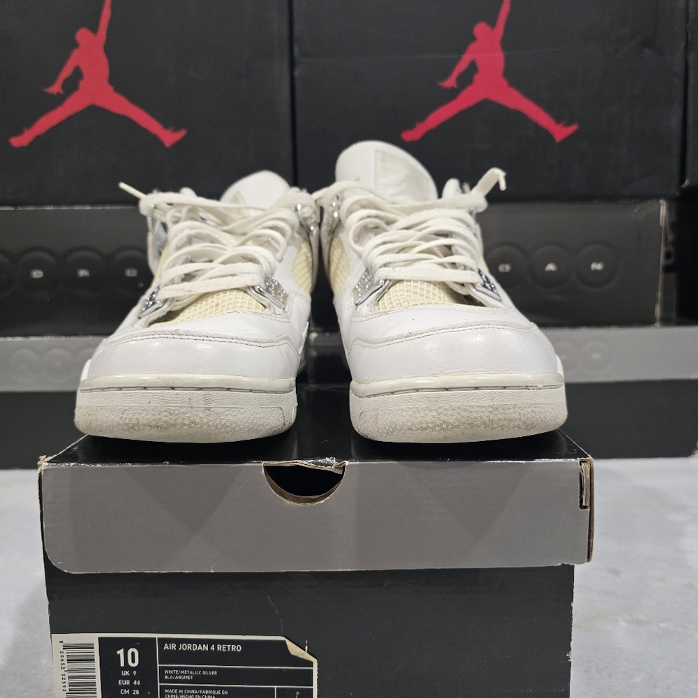 This is a pair of Nike Air Jordan 4 Retro "Pure Money" sneakers in a white and m